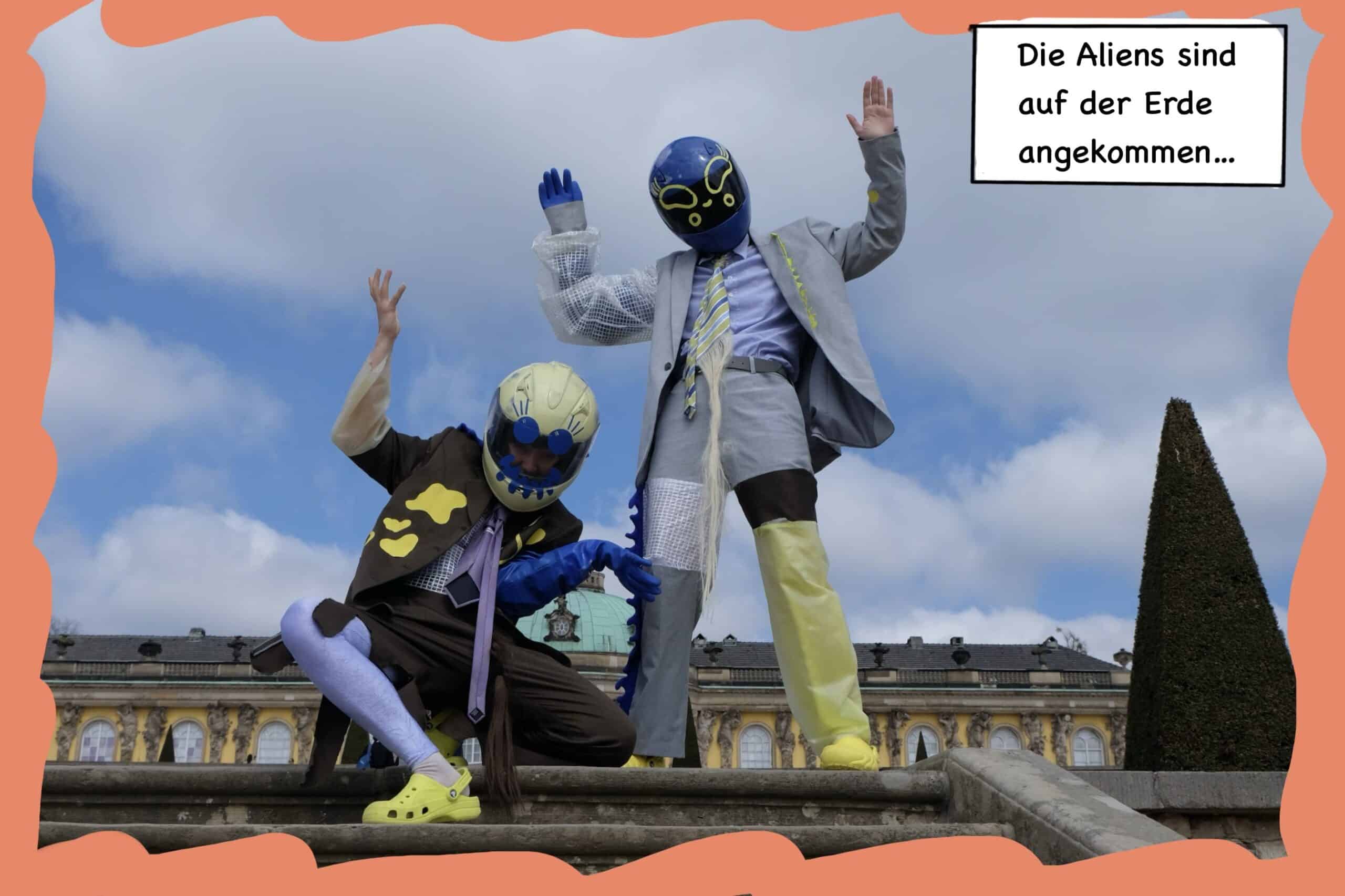 Zwei Außerirdische stehen oben auf einer Treppe und winken dem Betrachter zu