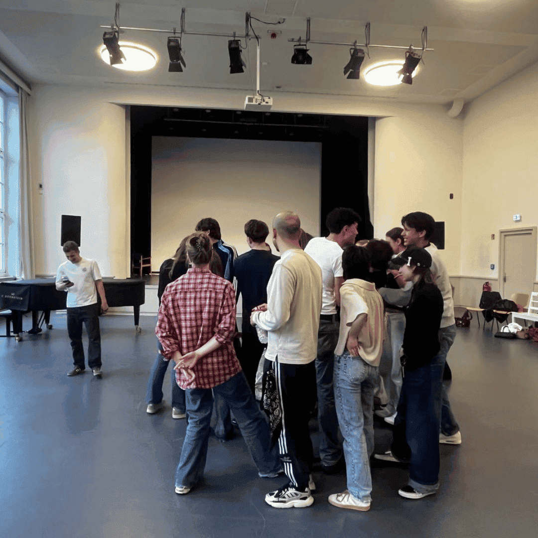 Tie Break Schulprobe2_Foto_Aina Zanoguera Schüler*innen stehen im engen Kreis in der Schulaula und proben ein neues Stück